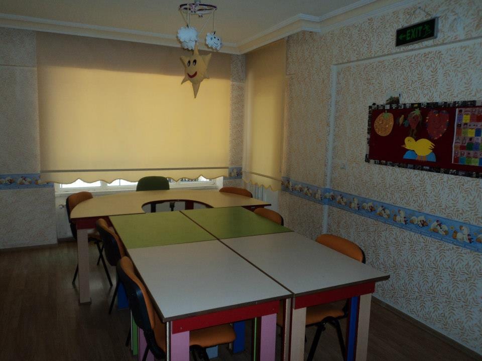 İlk Günebakan grup eğitim odası: çocuk boyunda masalar ve sandalyeler